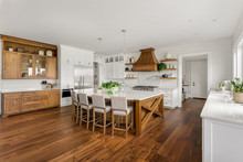 Beautiful Large Kitchen In New Home With Dark Hardwood Floors And Accents, And White Counters, Cabinets, And Backsplash
