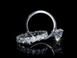 Interwoven solitaire diamond engagement ring, eternity wedding band on black background