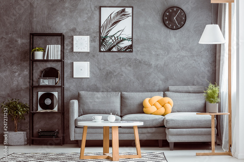 Botanical Poster And Clock On Grey Concrete Wall In Chic Living