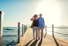 Senior Couple Walking On Pier By Red Sea. People Enjoying Vacation. Valentine's Day