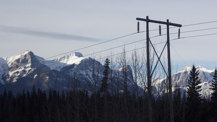 Power-lines running in front of sunlit mountains