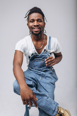 Wall Mural - African American on a white background in jeans and a white T-shirt, emotions, emotional person