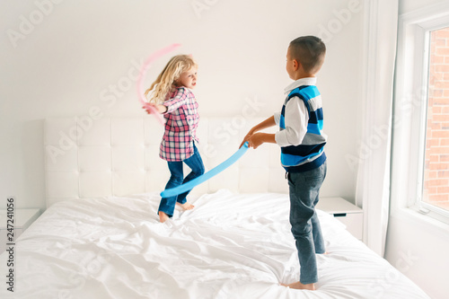 Two Caucasian Cute Adorable Funny Children Jumping On Bed In Bedroom And Playing Boy And Girl Are Having Fun Fighting With Balloons Best Friends Forever Happy Childhood Lifestyle Motion Blur Stock Photo Two Caucasian Cute Adorable Funny Children Jumping On Bed In Bedroom And Playing Boy And Girl Are Having Fun Fighting With Balloons Best Friends Forever Happy Childhood Lifestyle Motion Blur Stock Photo