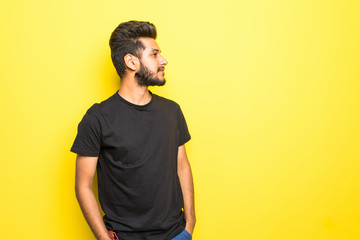 Indian bearded man standing isolated on yellow background