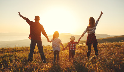 Happy family: mother, father, children son and daughter on sunset