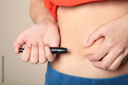Fotomural Woman doing insulin injection in stomach, closeup