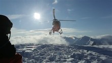 The Helicopter Left Skiers On The Slope Of The Mountain And Flew Raising A Cloud Of Snow