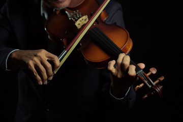 Violinist player hands close up shot  in black isolated background