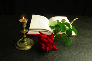 Wall Mural - An open book, a red rose and a burning candle