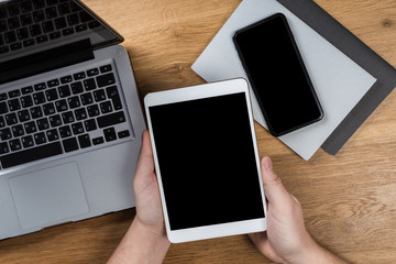 Man works using digital devices. Above view of desktop workspace.