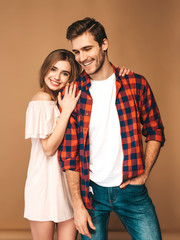 Portrait of Smiling Beautiful Girl and her Handsome Boyfriend laughing.Happy Cheerful Family. Valentine's Day. Posing on beige wall. Hugging