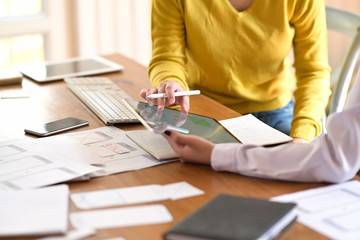 UI creative designer team designing wireframe layout for responsive mobile smartphone application in office