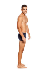 Shirtless handsome smiling man in panties on white background