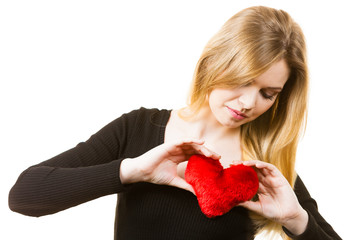 Nostalgic woman holding red heart