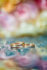 Wedding rings on table with water drops. Macro.