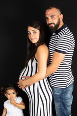 Wall Mural - pregnant mother lifestyle with daughter and father in black background