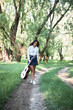 © soleg - young woman walking in the forest and playing guitar, summer nature, bright sunlight, shadows and green leaves, romantic feelings