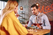 © Friends Stock - Romantic dinner. Man in blue shirt eating and talking with girlfriend