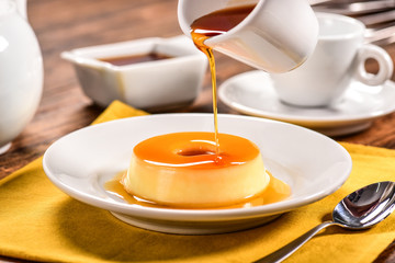 Vanilla pudim with caramel sauce on decorated scene