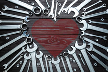 Wrenches And Heart On Dark Wooden Background. Concept Love For Their Work.