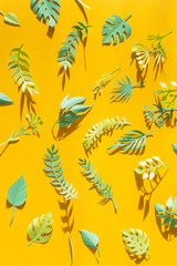 Naklejka na meble tropical leaves cut from paper in the sun rays on a yellow background. Summer concept
