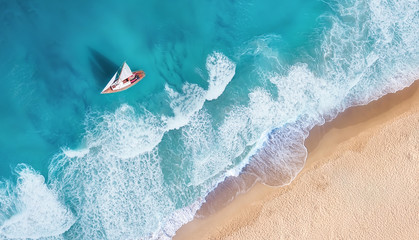 Wall Mural - Waves and yacht from top view. Turquoise water background from top view. Summer seascape from air. Top view from drone. Travel-image