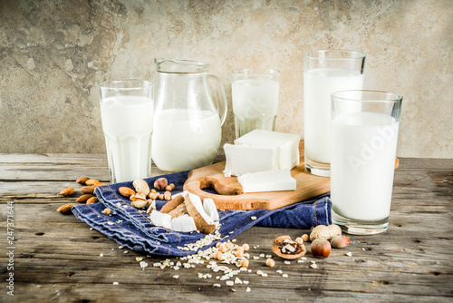 plant based vegan food and drink, Non-dairy milk and cheese tofu - from almond, nuts, soy beans, oats and coconut, wooden background copy space