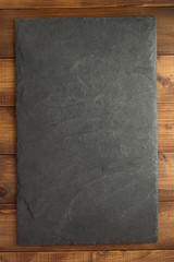 Wall Mural - slate stone at wooden background