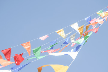 Colorful Party flags bunting hanging on blue sky for holiday decoration