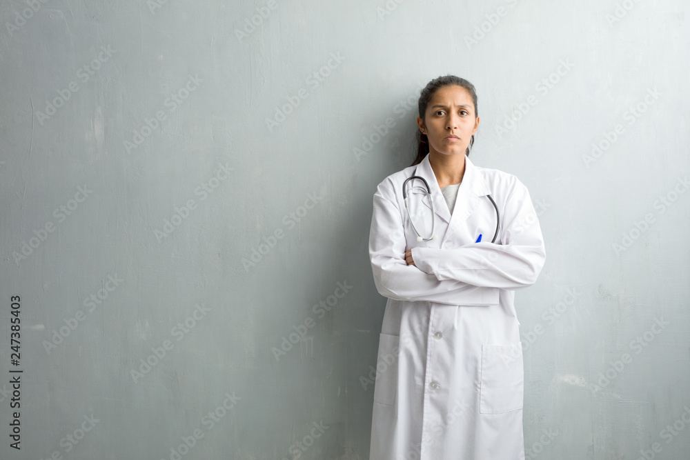 Young indian doctor woman against a wall very angry and upset, very ...