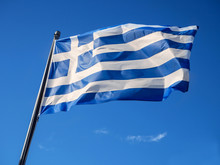 Greek Flag Waving In Blue Sky In Greece