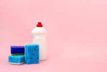 Bottle Of Cleaning Soap Standing Near Blue Sponges