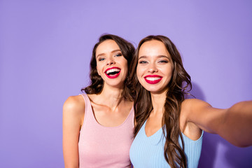 Wall Mural - Close up portrait two stunning she her ladies funky prom night make take selfies laugh laughter celebrity makeup cosmetics wear festive dresses isolated purple violet vivid vibrant bright background