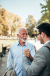 © bnenin - Young businessman meeting with senior colleague outdoors.