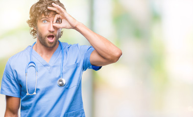 Canvas Print - Handsome hispanic surgeon doctor man over isolated background doing ok gesture shocked with surprised face, eye looking through fingers. Unbelieving expression.