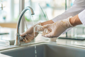 scientist wash beaker from poisonous acid after experiments b