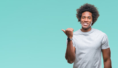 Afro american man over isolated background smiling with happy face looking and pointing to the side with thumb up.