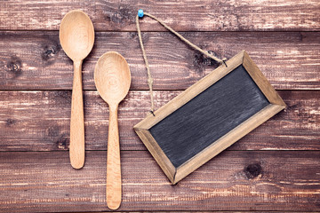 Wall Mural - Wooden kitchen spoons with blank frame on brown table