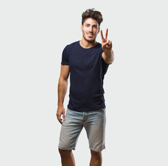 Wall Mural - Young handsome man standing showing number two, symbol of counting, concept of mathematics, confident and cheerful