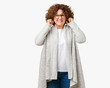 © Krakenimages.com - Beautiful middle ager senior woman wearing jacket and glasses over isolated background covering ears with fingers with annoyed expression for the noise of loud music. Deaf concept.