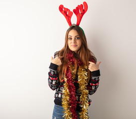 Young pretty woman wearing christmas clothes surprised, feels successful and prosperous