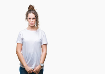 Wall Mural - Beautiful young brunette curly hair girl wearing glasses over isolated background with serious expression on face. Simple and natural looking at the camera.