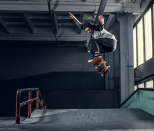 Skateboarder Jumping High On Mini Ramp At Skate Park Indoor.