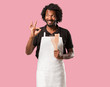 © Asier - Handsome african american baker cheerful and confident doing ok gesture, excited and screaming, concept of approval and success