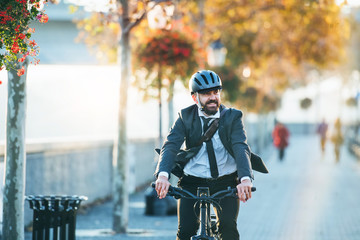 hipster businessman commuter with electric bicycle traveling home from work in city.