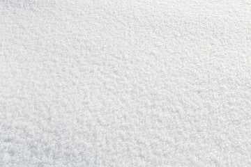 Fresh fluffy snow texture in the sun. Winter background with high angle view