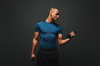 © Friends Stock - Achieving best results. Dark skinned sportsman working out with dumbbells over dark background