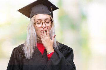 Sticker - Young blonde woman wearing graduate uniform over isolated background bored yawning tired covering mouth with hand. Restless and sleepiness.