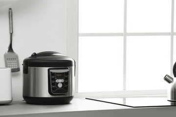 Sticker - Modern electric multi cooker on kitchen countertop. Space for text