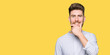 © Krakenimages.com - Young handsome man looking confident at the camera with smile with crossed arms and hand raised on chin. Thinking positive.